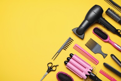 Flat lay composition of professional hairdresser tools on orange background, space for text