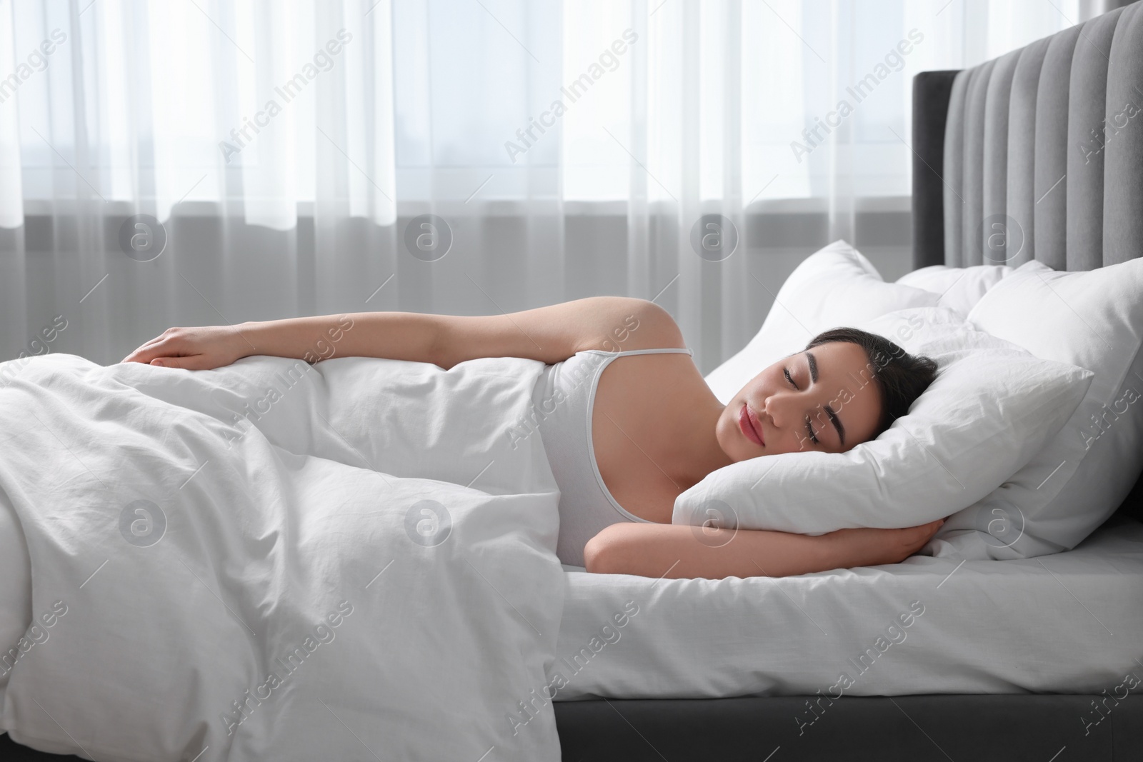 Photo of Beautiful young woman sleeping in soft bed at home