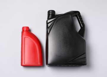 Photo of Motor oil in different canisters on light background, flat lay