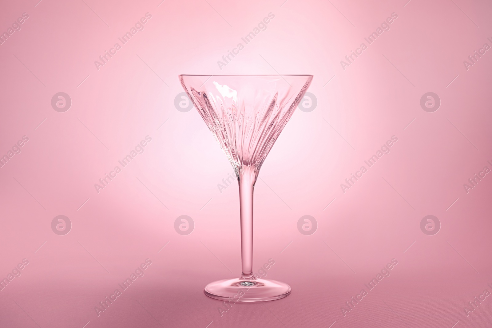 Photo of Elegant empty martini glass on pink background