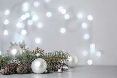 Photo of Christmas decoration on table against blurred lights. Space for text