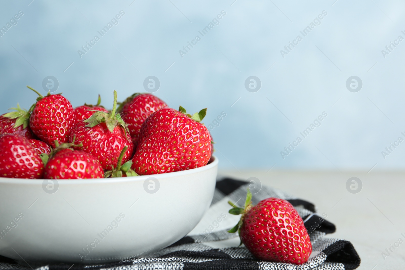 Photo of Delicious ripe strawberries in bowl on table, closeup