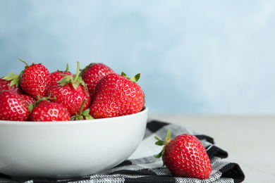 Photo of Delicious ripe strawberries in bowl on table, closeup