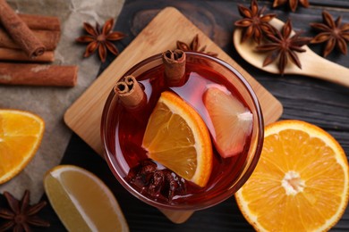 Glass of aromatic punch drink and ingredients on table, flat lay