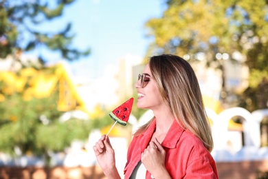 Young pretty girl with candy having fun in park