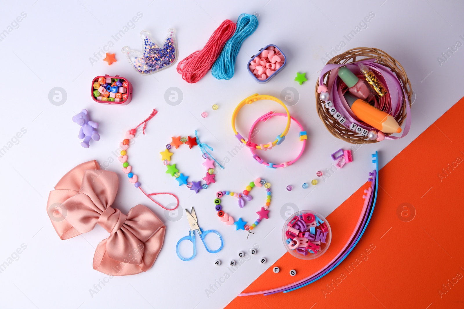 Photo of Kid's handmade beaded jewelry and different supplies on color background, flat lay