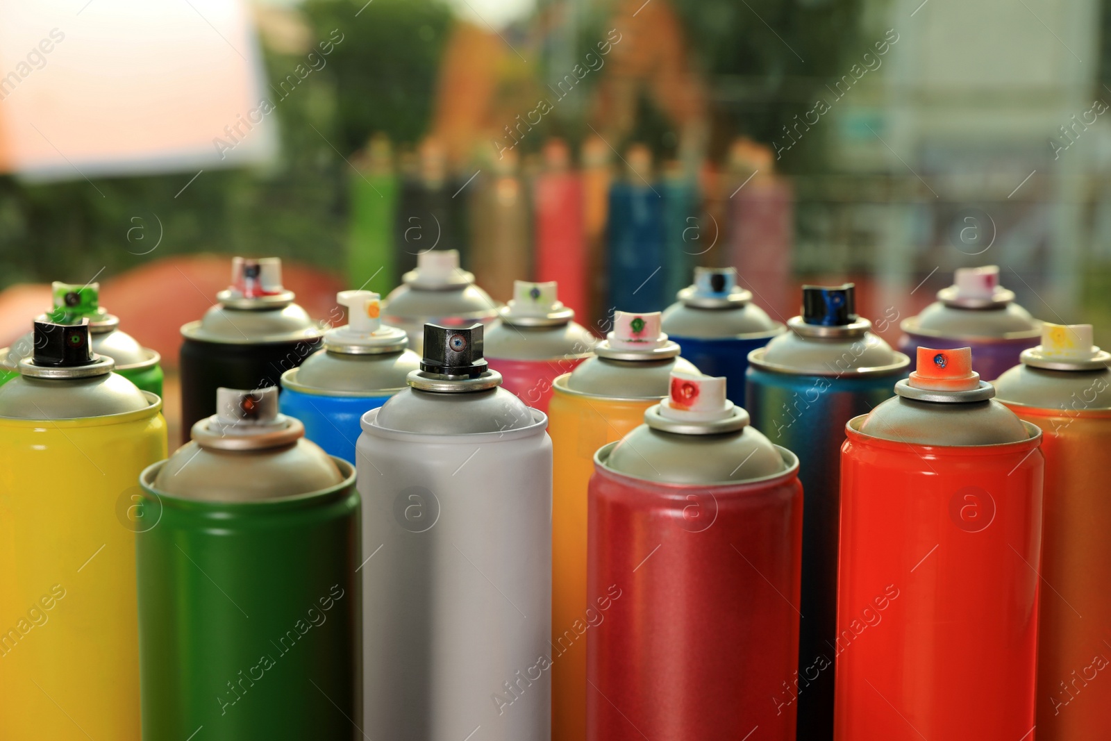 Photo of Many cans of different graffiti spray paints near window