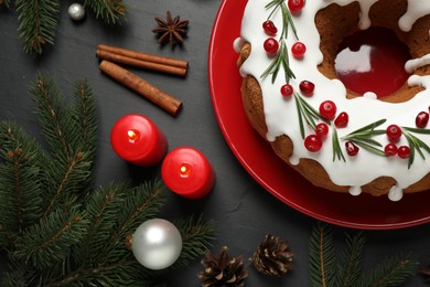 Flat lay composition with traditional Christmas cake and decorations on dark grey table