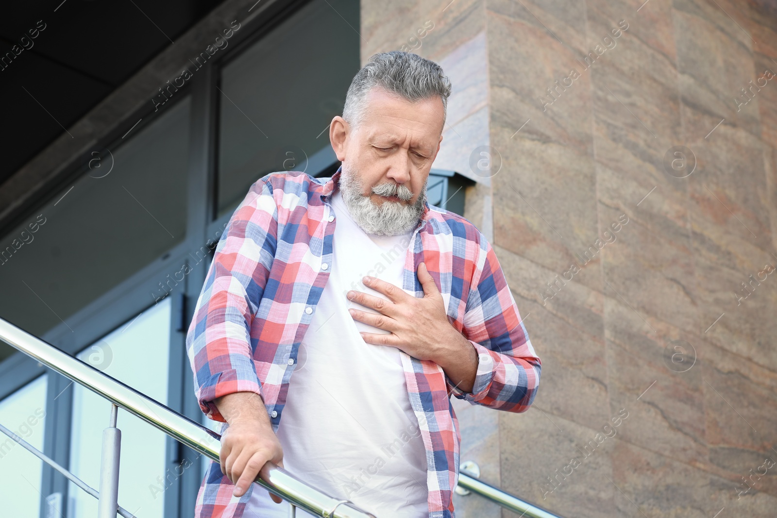 Photo of Mature man having heart attack, outdoors