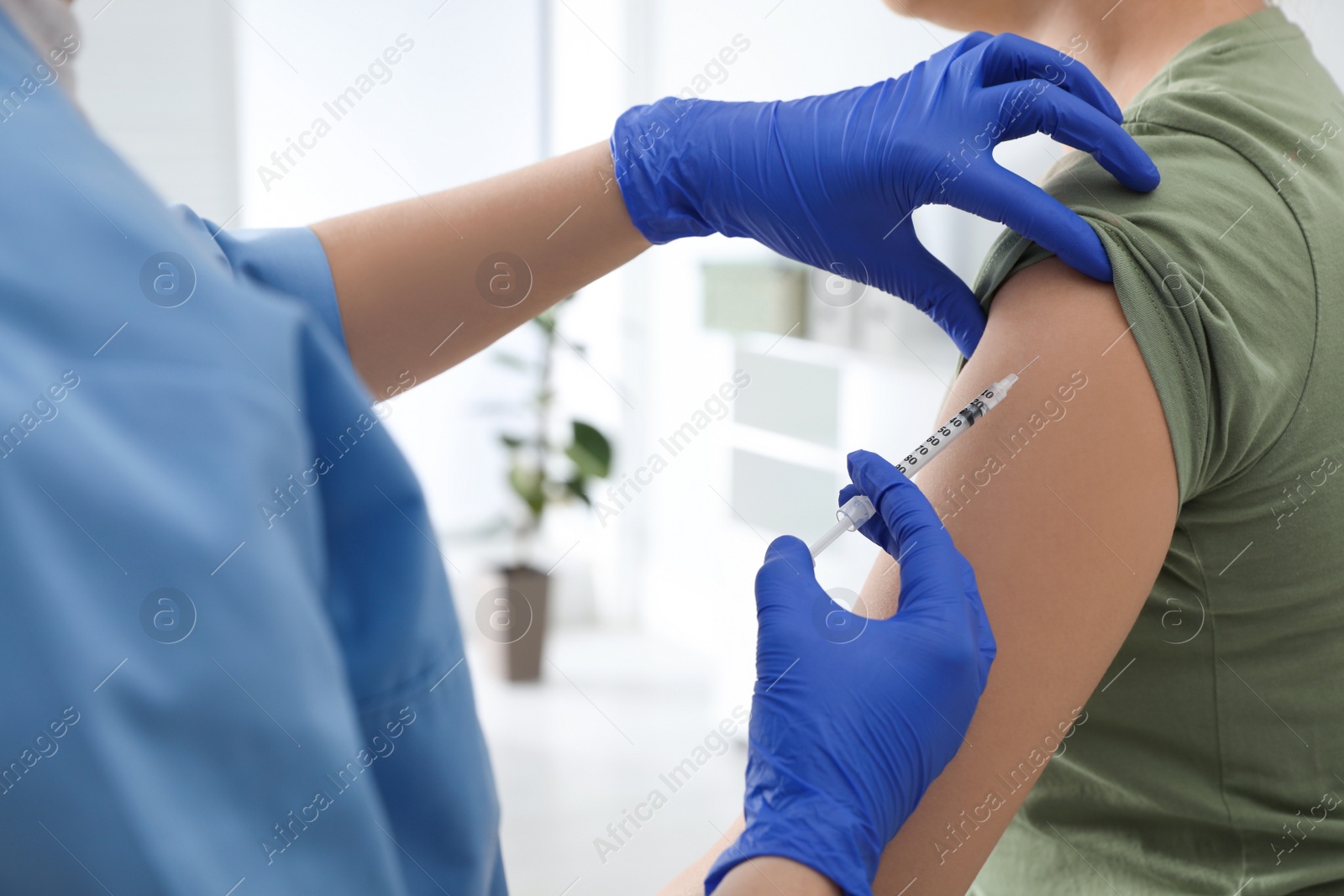 Photo of Doctor giving injection to woman in hospital, closeup. Immunization concept