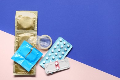 Photo of Condoms and contraception pills on color background, flat lay and space for text. Choosing birth control method