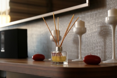 Photo of Reed air freshener on wooden table indoors