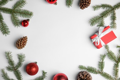 Christmas greeting card with space for text. Flat lay composition of fir tree branches and festive decor on white background