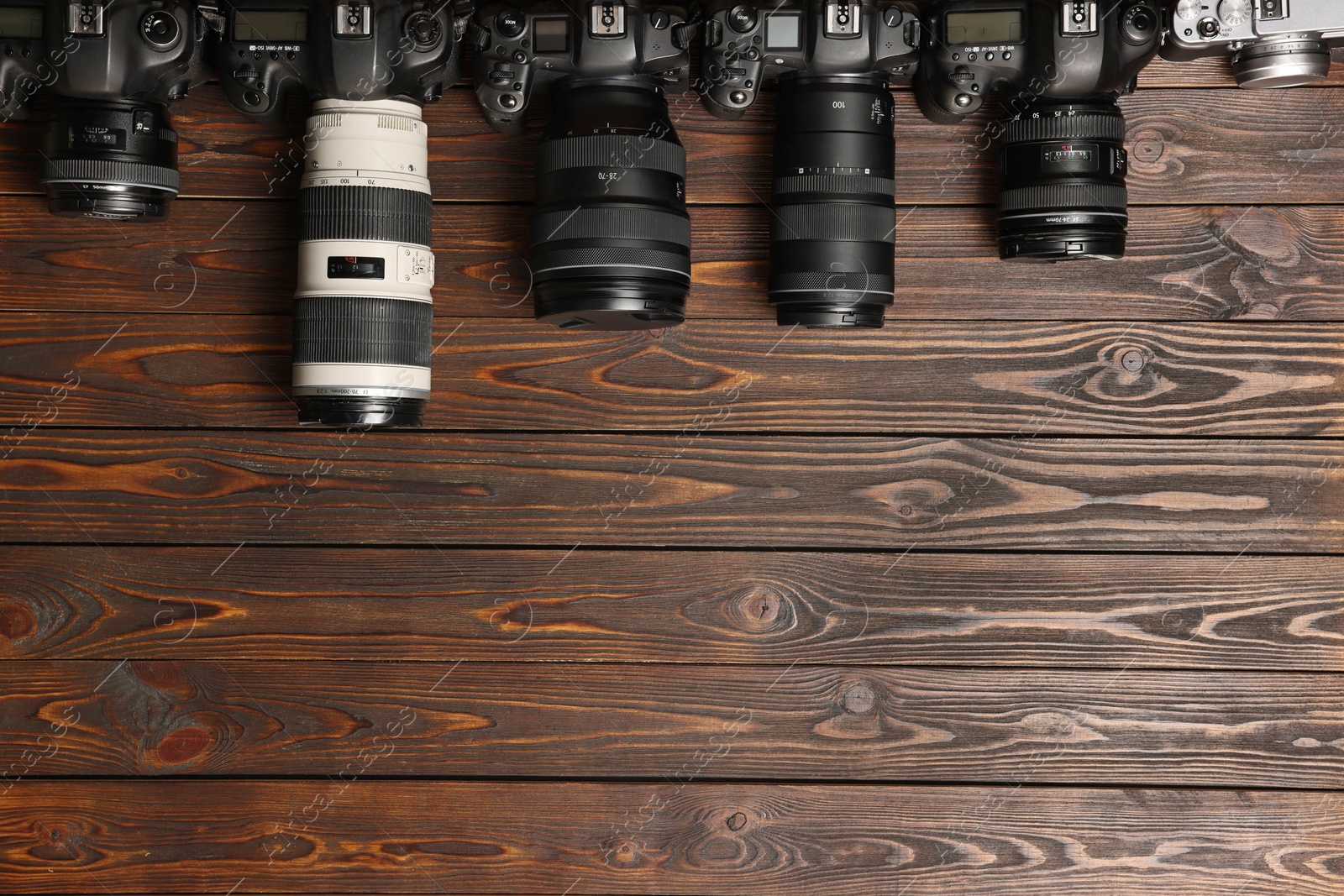 Photo of Modern cameras on wooden table, flat lay. Space for text