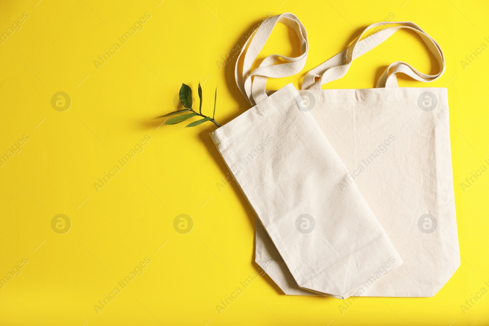 Photo of Flat lay composition with eco tote bags and space for text on color background