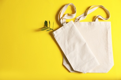 Photo of Flat lay composition with eco tote bags and space for text on color background