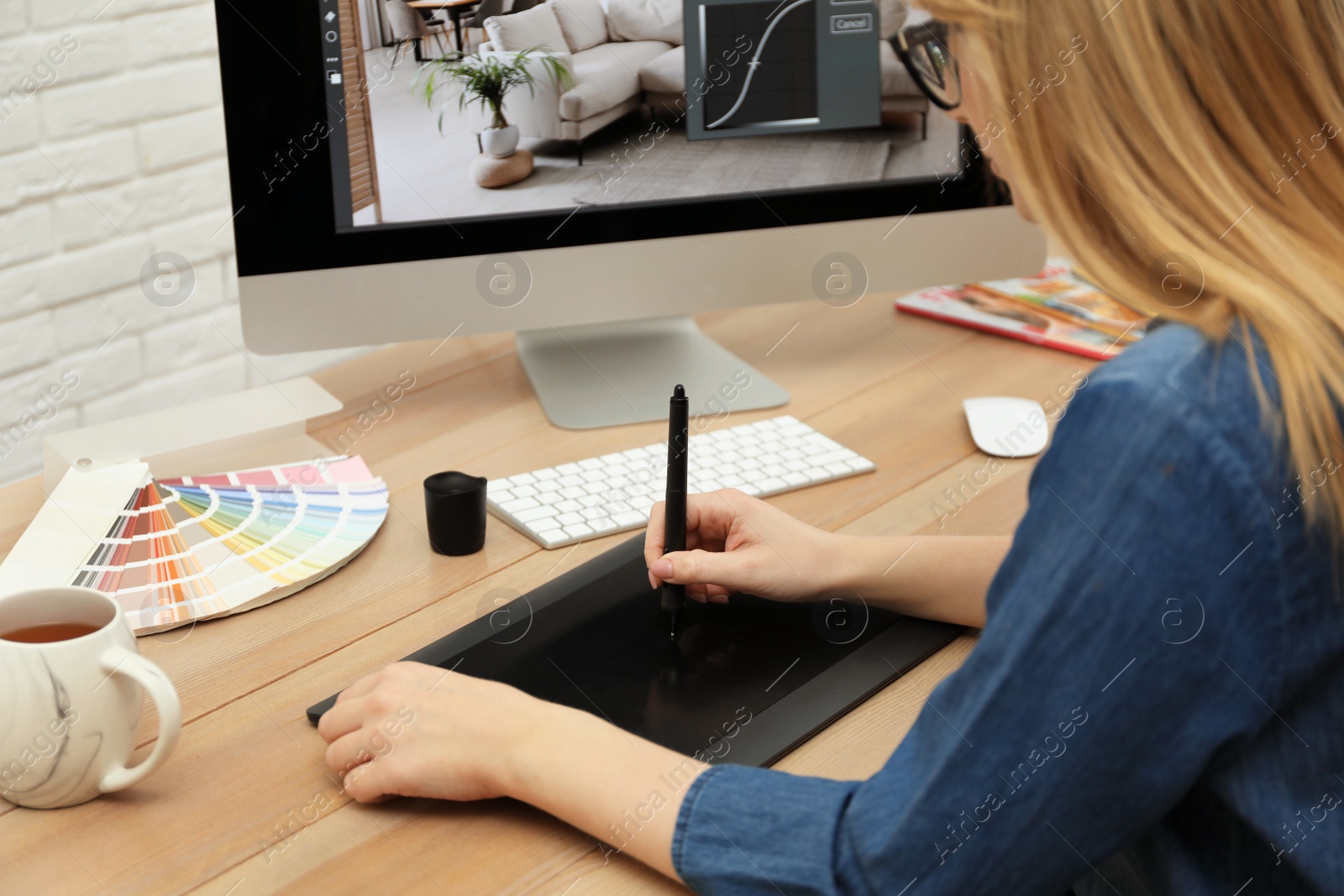 Photo of Professional retoucher working on graphic tablet at desk, closeup