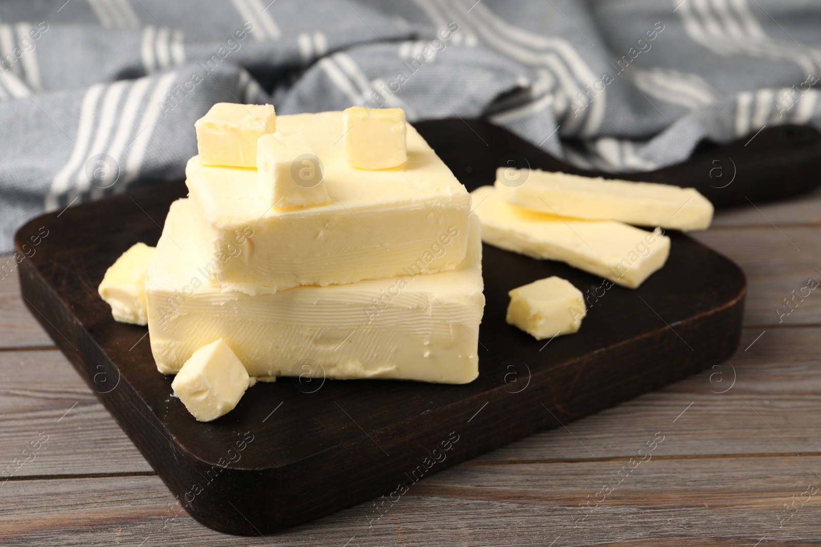 Photo of Pieces of tasty butter on wooden table