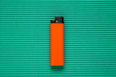 Stylish small pocket lighter on green corrugated fiberboard, top view