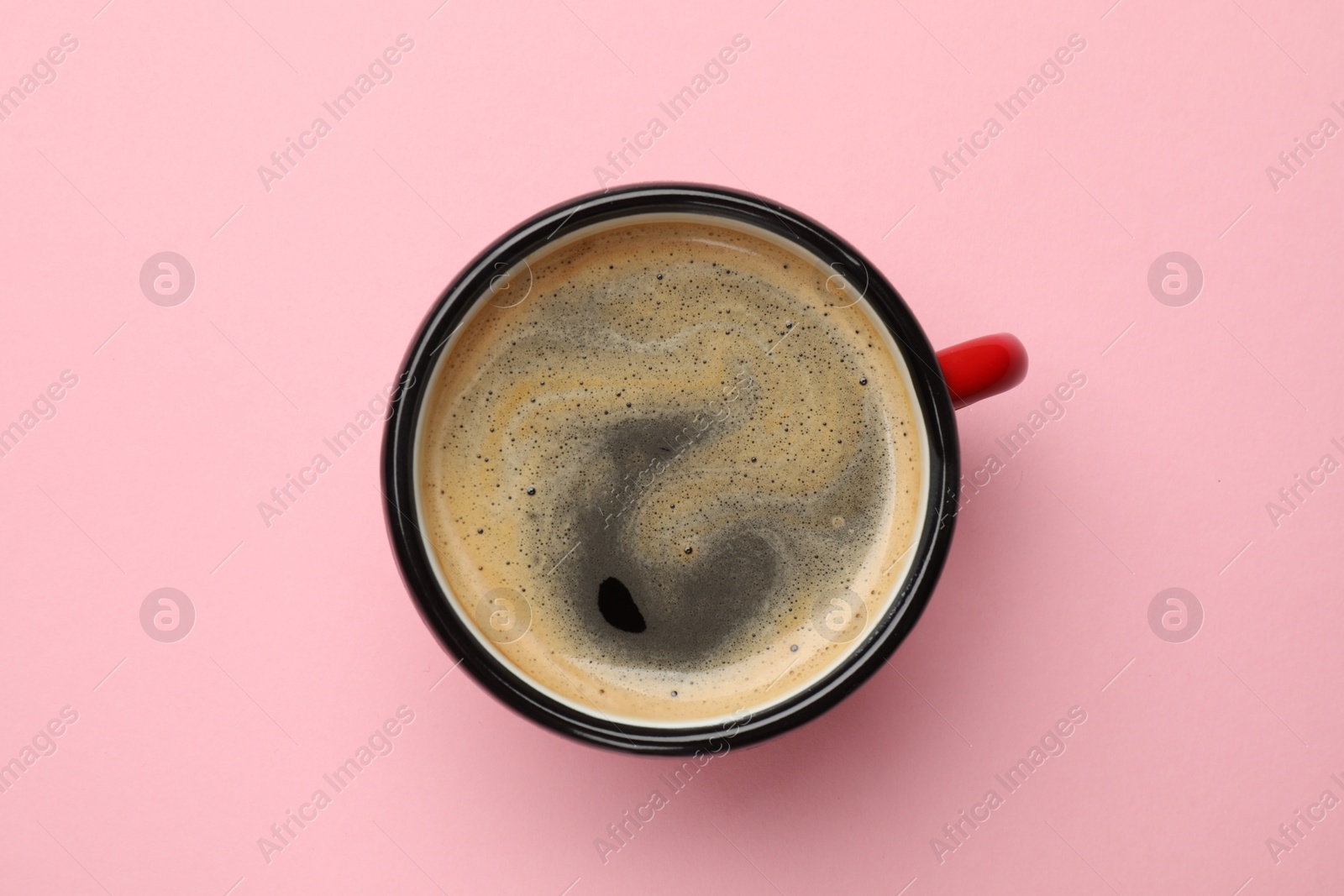 Photo of Fresh coffee in cup on pink background, top view