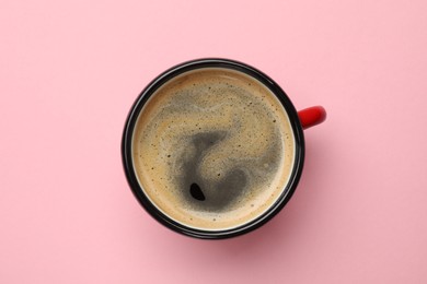 Fresh coffee in cup on pink background, top view