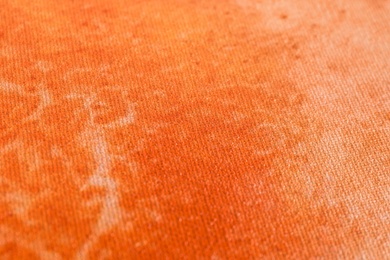 Orange fabric with pattern as background, closeup view