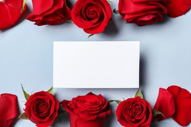 Blank card, beautiful red roses and petals on grey background, flat lay. Space for text