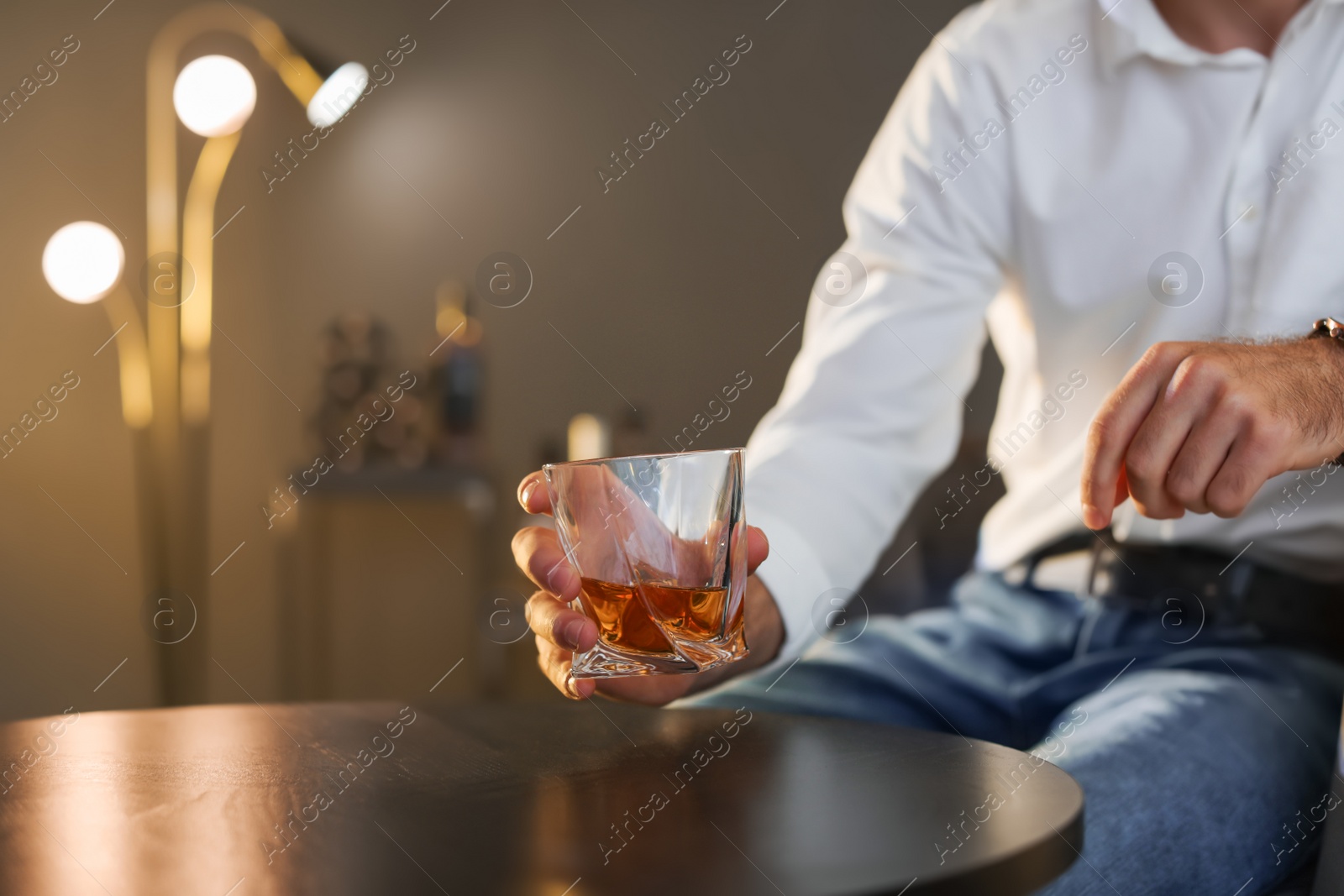 Photo of Man with glass of whiskey sitting at table, closeup. Space for text