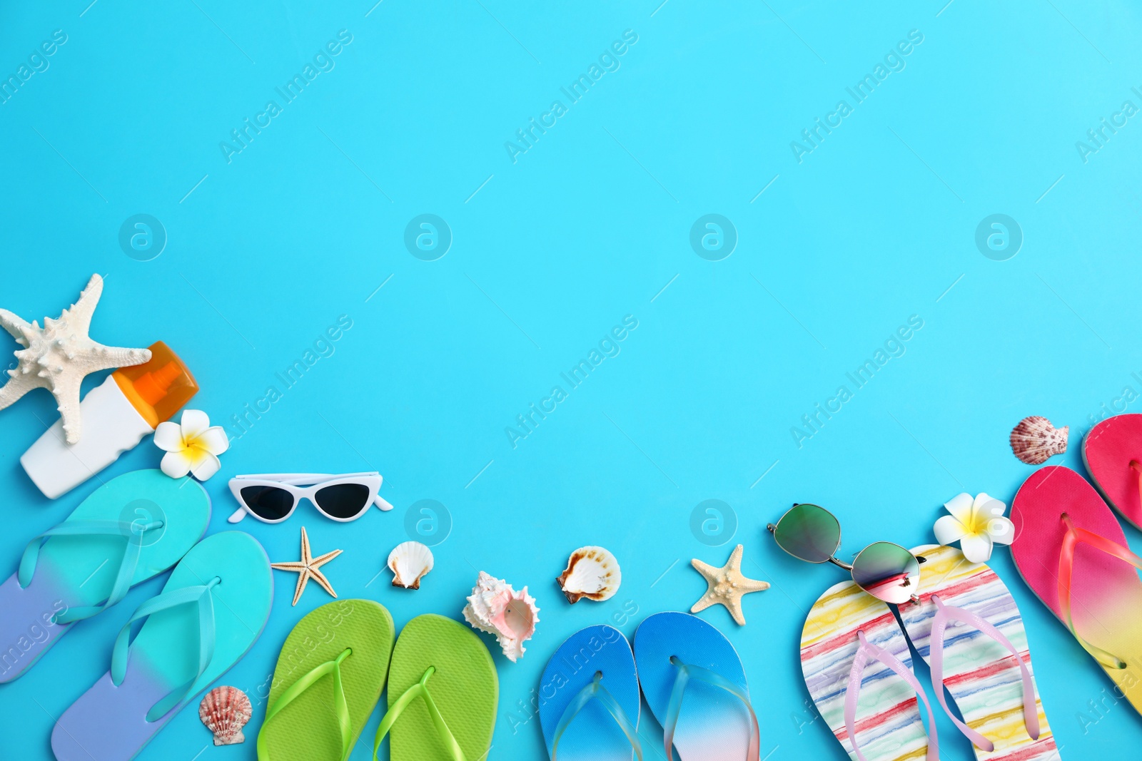 Photo of Flat lay composition with different flip flops on blue background, space for text. Summer beach accessories