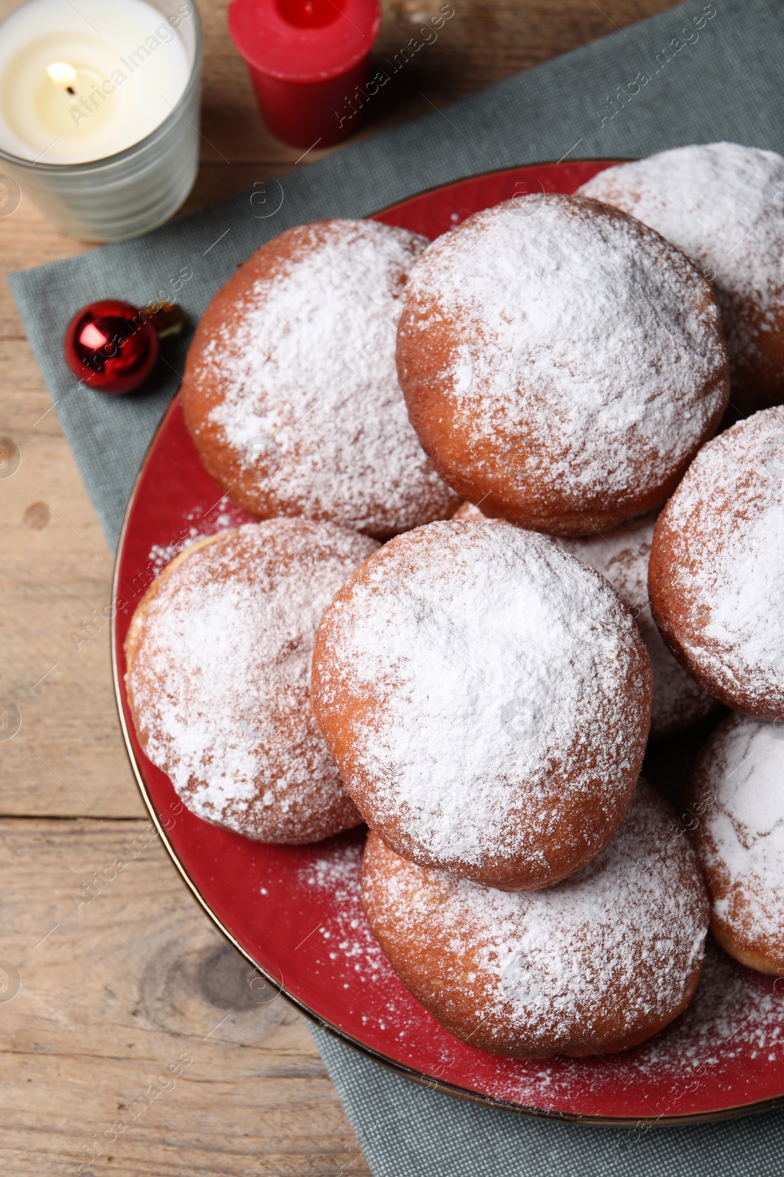 Photo of Delicious sweet buns and burning candles on table, flat lay