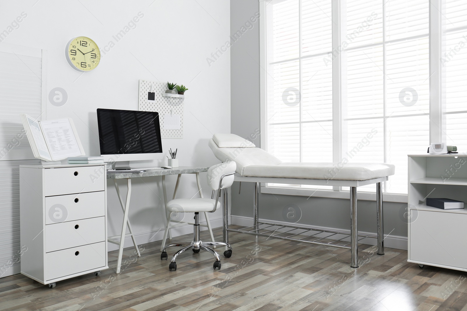 Photo of Modern medical office interior with computer and examination table