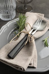 Photo of Stylish setting with cutlery and napkin on black table, closeup