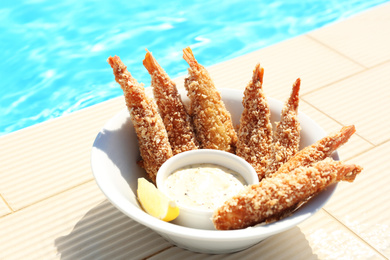 Delicious fried shrimps with sauce near swimming pool