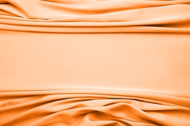 Texture of delicate light orange silk as background, top view