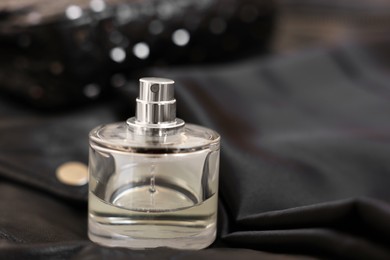 Photo of Bottle of perfume on black leather jacket, closeup