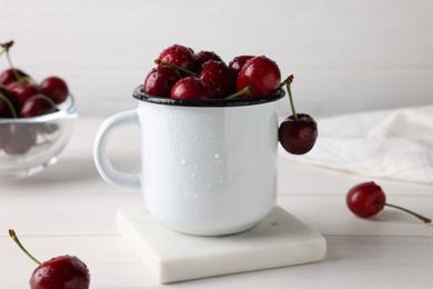 Fresh ripe cherries with water drops on white wooden table, closeup