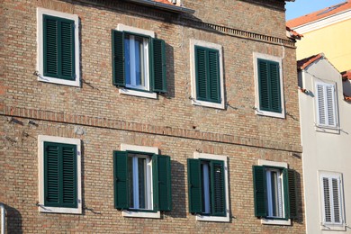 Photo of Exterior of old residential buildings with windows and wooden shutters