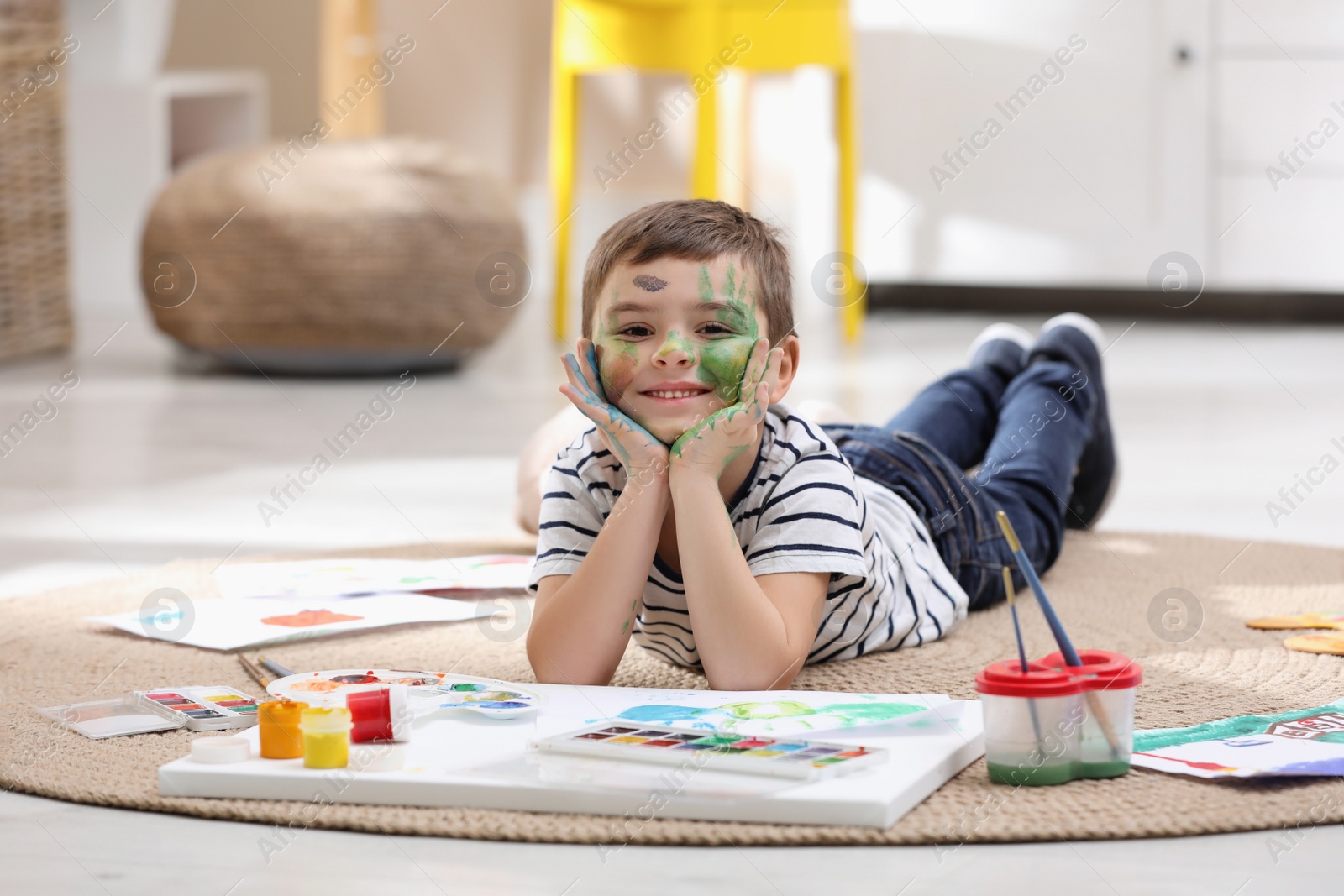 Photo of Happy little child with paint on face in room