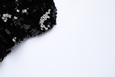 Photo of Black shiny sequin fabric on white background, top view. Space for text