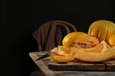 Photo of Slices of assorted melons on table against black background