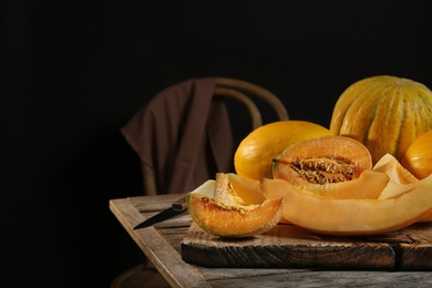 Slices of assorted melons on table against black background