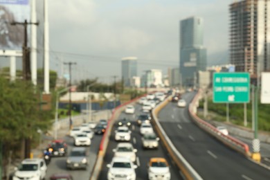 Photo of Blurred view of asphalt highway with cars and buildings in city