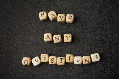 Phrase Have Any Questions made of wooden cubes on black background, flat lay
