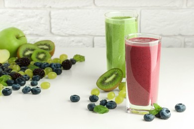 Photo of Fresh colorful fruit smoothies and ingredients on white table