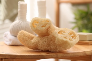 Loofah sponges on wooden table indoors, closeup