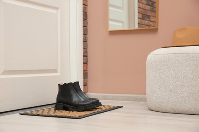 Photo of Stylish shoes on door mat in hall