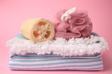 Photo of Shower puff, loofah sponge and towel on pink background