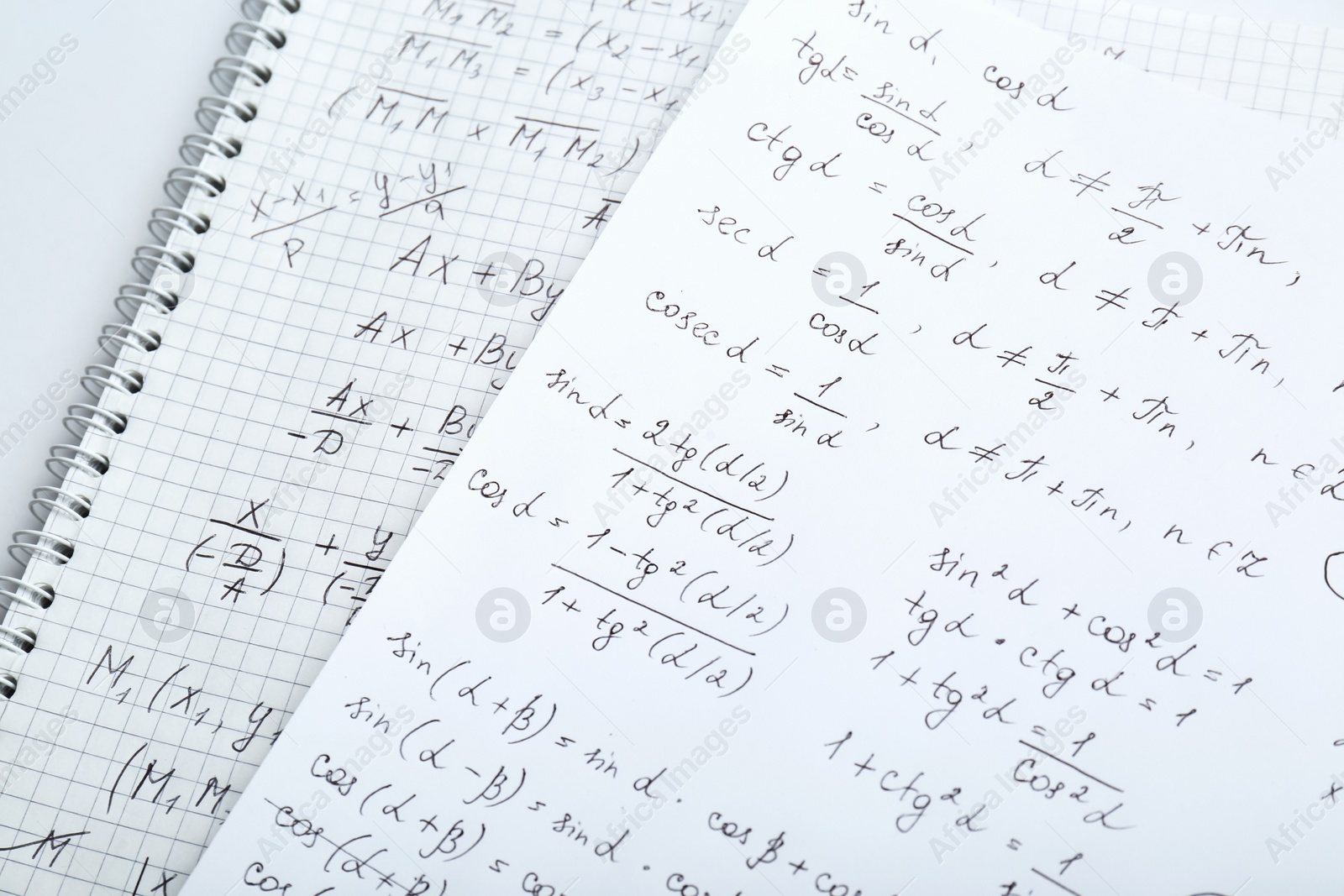 Photo of Sheets of paper with different mathematical formulas on table, closeup