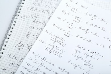 Photo of Sheets of paper with different mathematical formulas on table, closeup