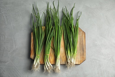 Fresh green onion on wooden board, top view